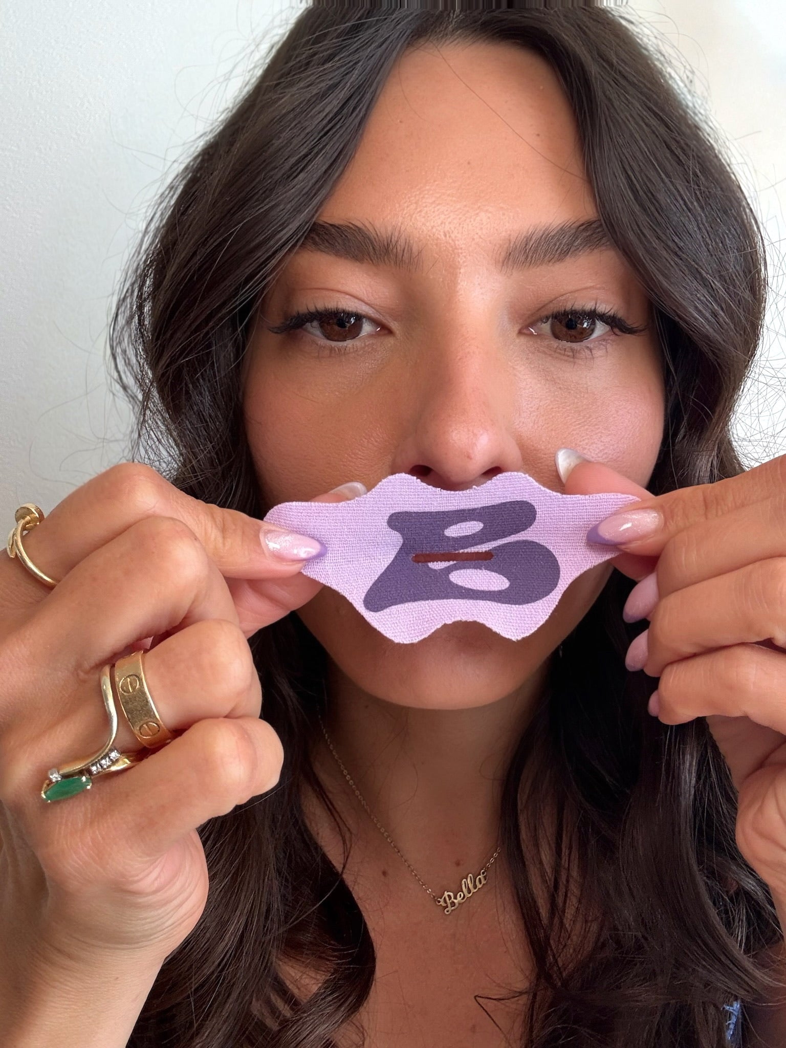 Woman holding Bedrock lilac mouth tape made with premium silk material for deep sleep, beauty sleep, and natural breathing